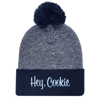 Gray and navy beanie with pom-pom and 'Hey, Cookie' text on a white background