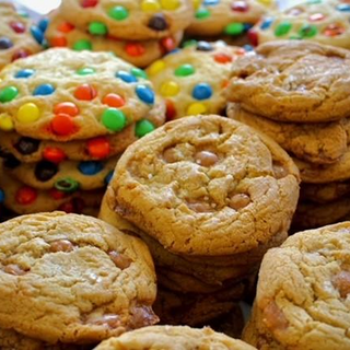 Cookies with colorful candies and plain cookies stacked together.