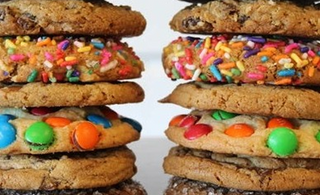 Stacks of cookies with colorful toppings on a white background