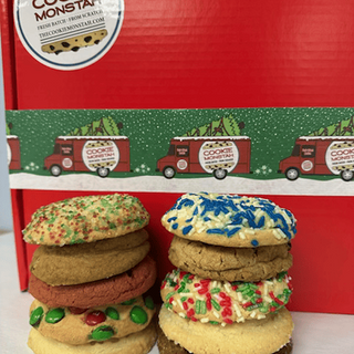 Stacks of colorful cookies in front of a red box with 'Cookie Monster' branding.
