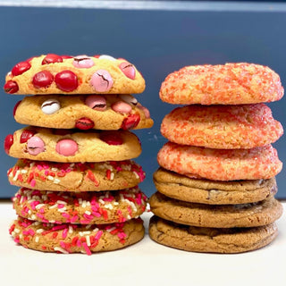 Stacks of colorful cookies with sprinkles and candy pieces, indicative of Valentine's Day themes.